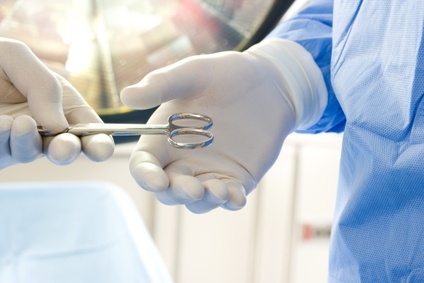 Surgeon giving colleague medical tool, close-up of hands